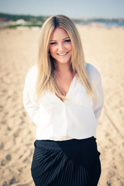 Jonge mooie vrouw blonde houdingen op een strand — Stockfoto