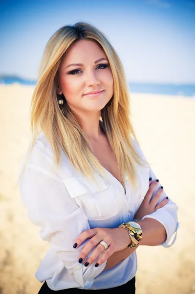 Junge schöne Blondine posiert am Strand — Stockfoto