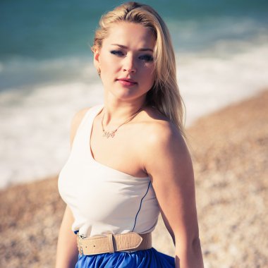 genç güzel kadın bir plajda sarışın pozlar