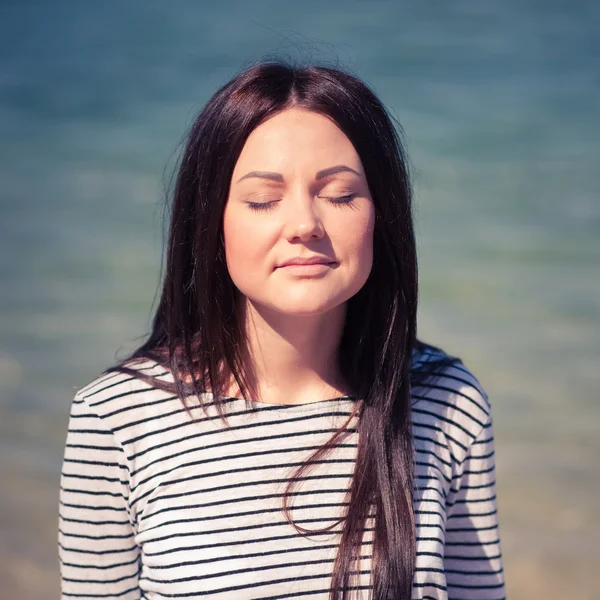 Mooie brunette vrouw op het strand — Stockfoto