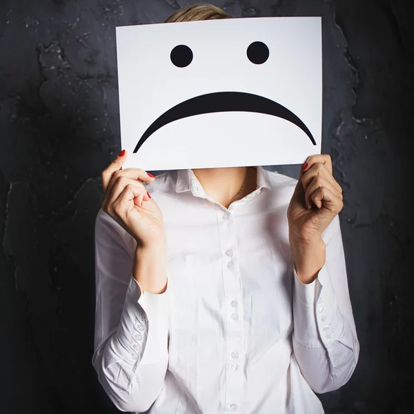 Woman holding frames with sad faces — Stock Photo, Image