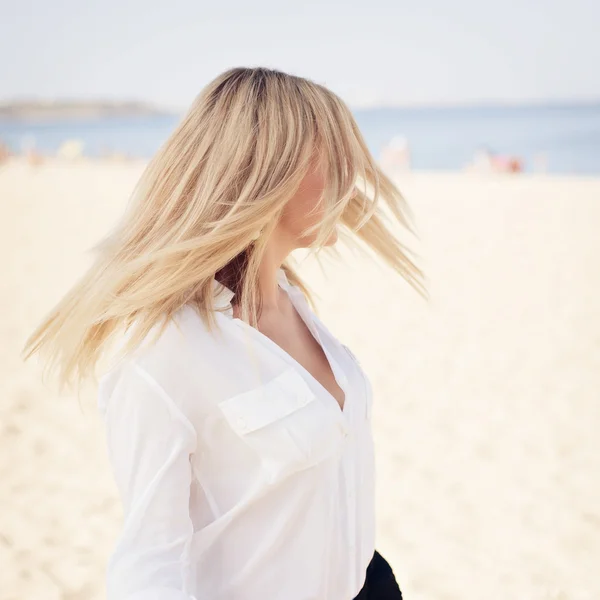 Junge schöne Blondine posiert am Strand — Stockfoto