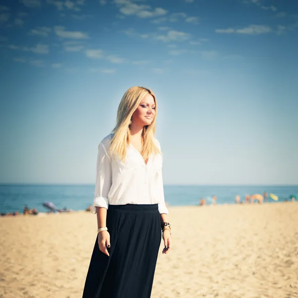 Junge schöne Blondine posiert am Strand — Stockfoto