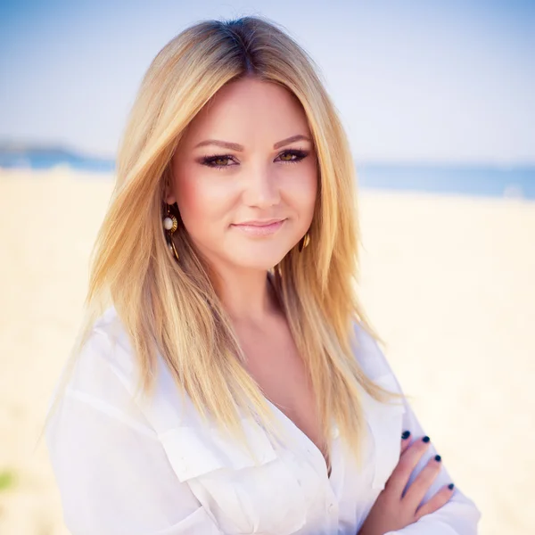 Jonge mooie vrouw blonde houdingen op een strand — Stockfoto