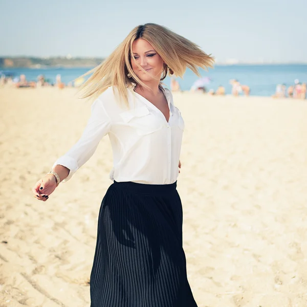 Junge schöne Blondine posiert am Strand — Stockfoto