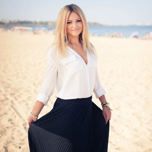 Jonge mooie vrouw blonde houdingen op een strand — Stockfoto