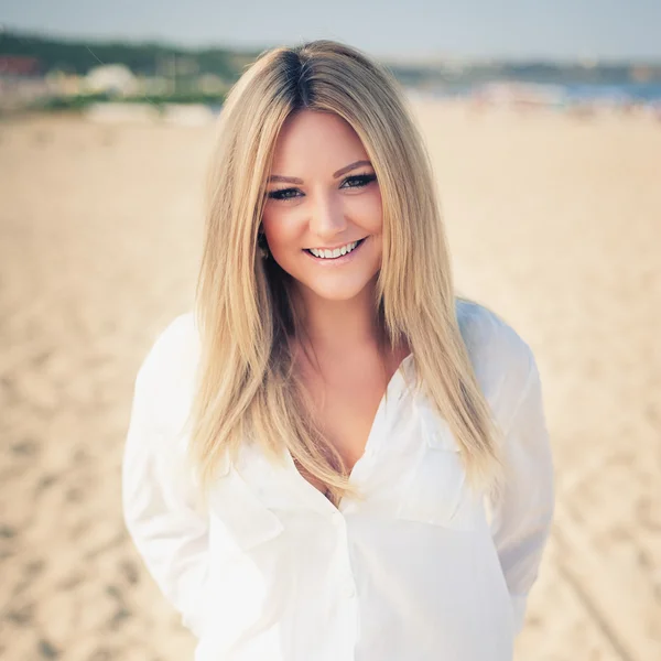 Jonge mooie vrouw blonde houdingen op een strand — Stockfoto