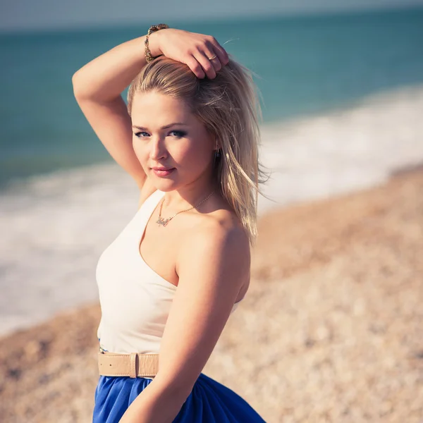 Jovem bela mulher loira posa em uma praia — Fotografia de Stock