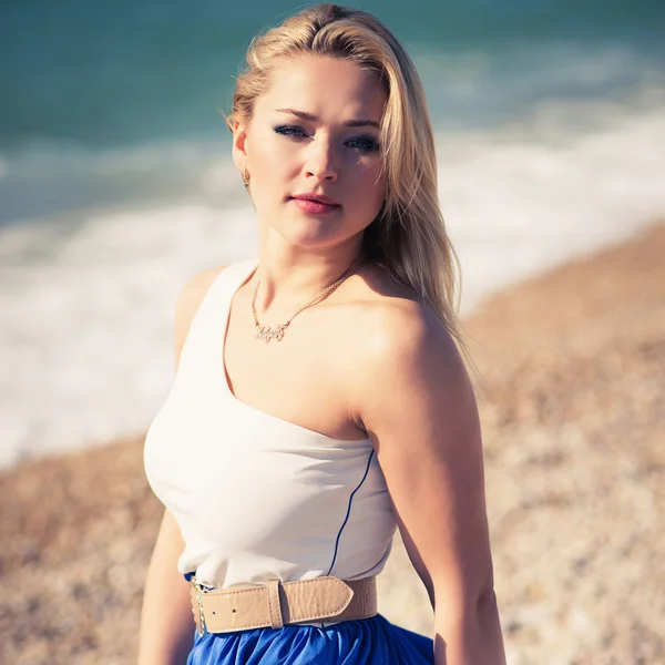 genç güzel kadın bir plajda sarışın pozlar