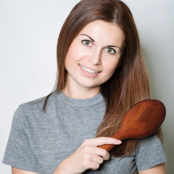 Young brunette beautiful woman combing long hairs — Stock Photo, Image