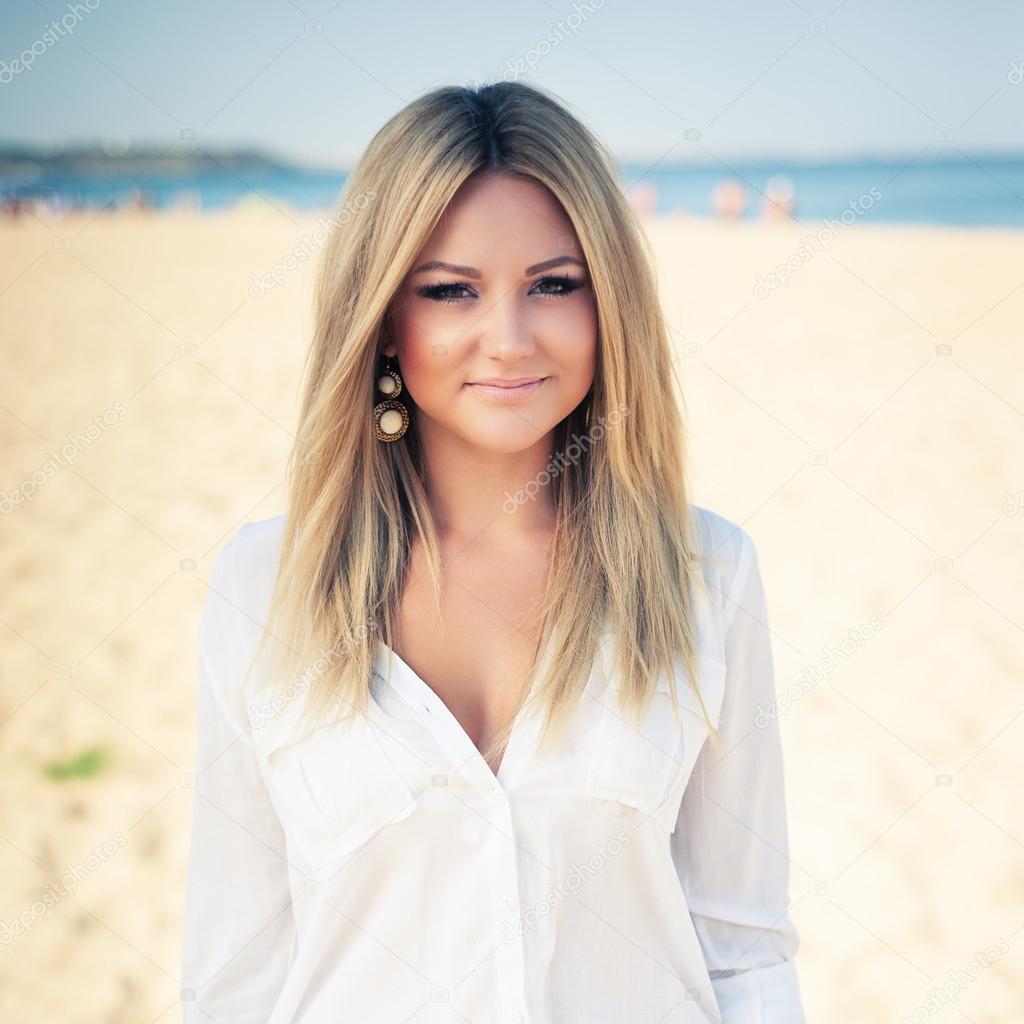 young beautiful woman blonde poses on a beach