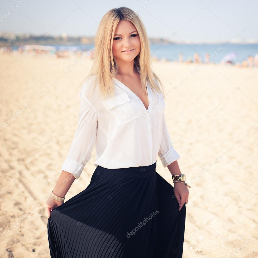young beautiful woman blonde poses on a beach
