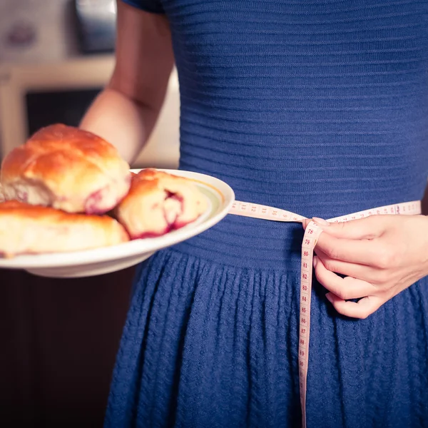 Young woman holds pie and a measuring tape — 스톡 사진