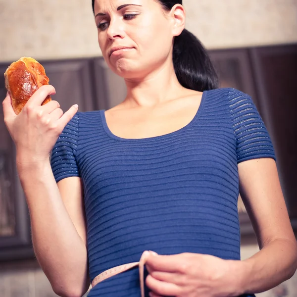 Genç kadın tutan pasta ve bir ölçüm bandı — Stok fotoğraf