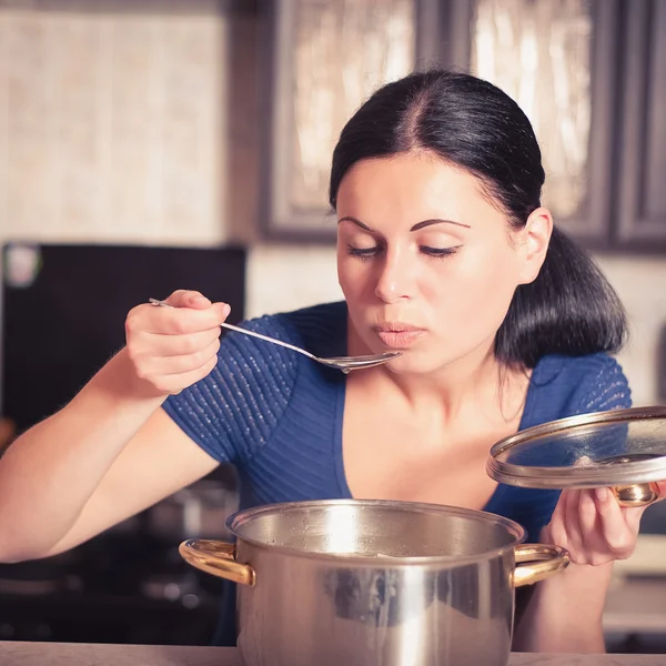 Junge Hausfrau kocht Essen in Küche — Stockfoto