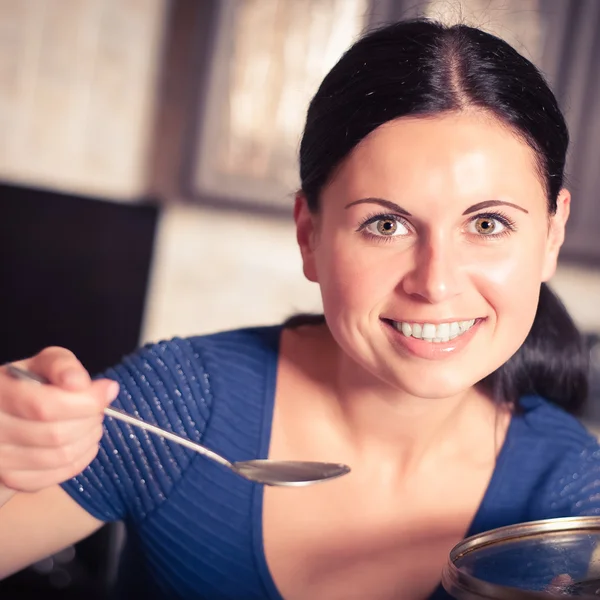 Jovem dona de casa cozinha comida na cozinha — Fotografia de Stock