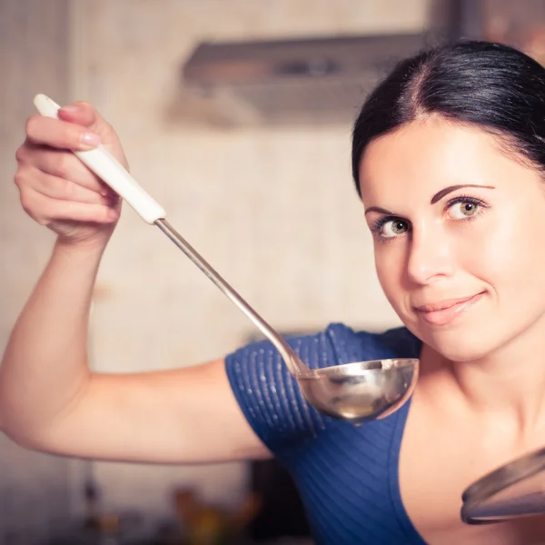 Молодая домохозяйка готовит еду на кухне — стоковое фото