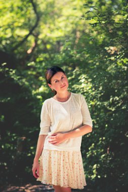 yemyeşil ağaçlar arasında genç bir kadın