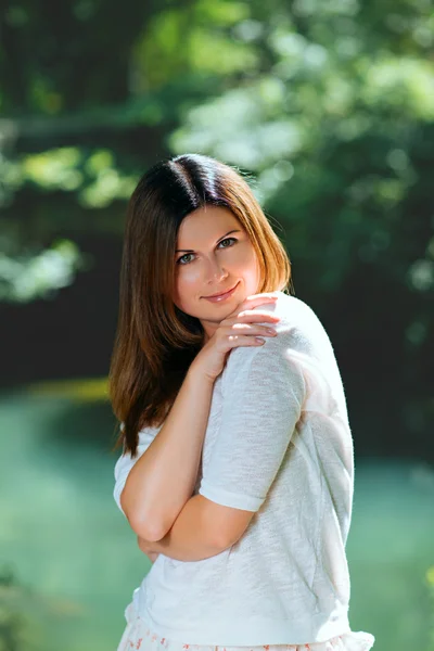 Young woman  among green trees — Stock Photo, Image