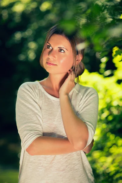 Ung kvinna bland gröna träd — Stockfoto