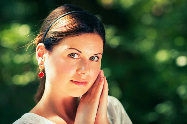 Jonge vrouw onder de groene bomen — Stockfoto