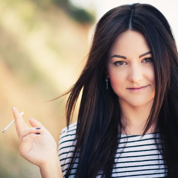 Hermosa joven que fuma un cigarrillo — Foto de Stock