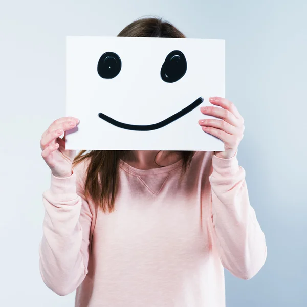 Vrouw met een karton met een smiley — Stockfoto