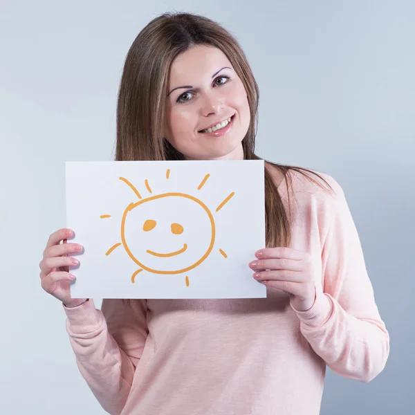 Mujer joven sosteniendo un cartón con un sol — Foto de Stock