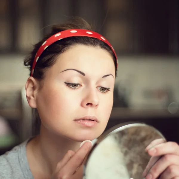 युवा महिला घर पर अपने चेहरे की देखभाल कर रही है — स्टॉक फ़ोटो, इमेज