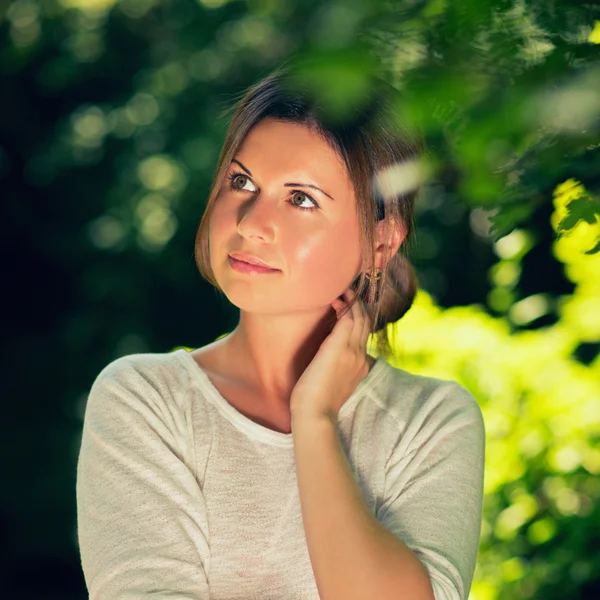 Jonge vrouw onder de groene bomen — Stockfoto