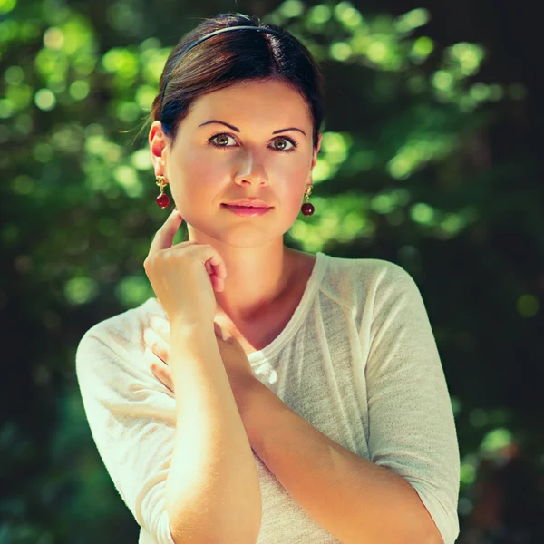 Jonge vrouw onder de groene bomen — Stockfoto