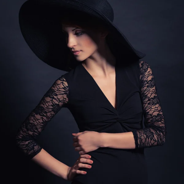 Belle fille en robe noire et chapeau — Photo