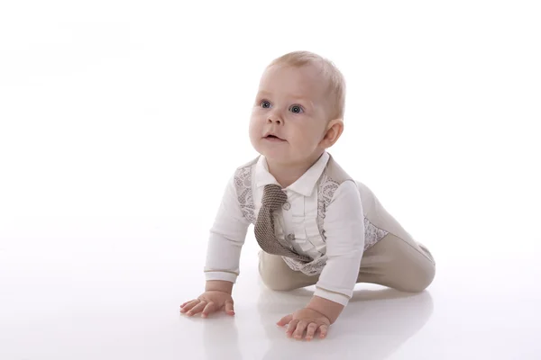 Bebê-menino sorridente em um terno romper rastejando — Fotografia de Stock