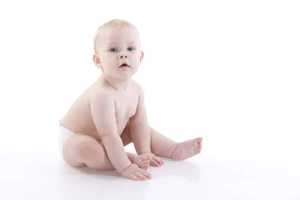 Baby-boy in a diaper sitting on the floor — Stock Photo, Image