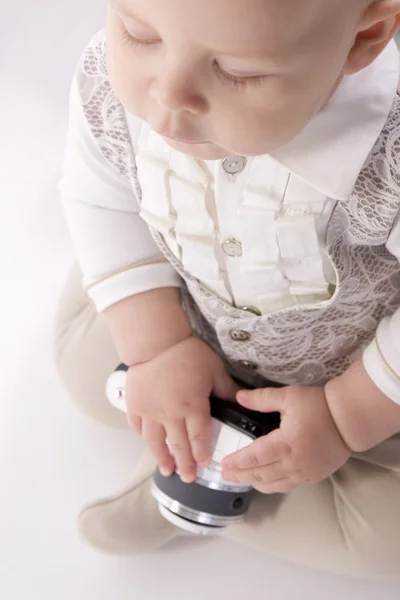 Niño en traje beige está entregando una cámara —  Fotos de Stock