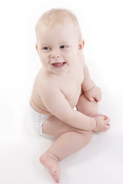 Glimlachende baby-jongen in een luier zittend op de vloer — Stockfoto