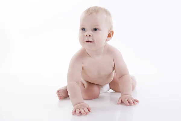 Bebê sorridente em uma fralda rastejando no chão — Fotografia de Stock
