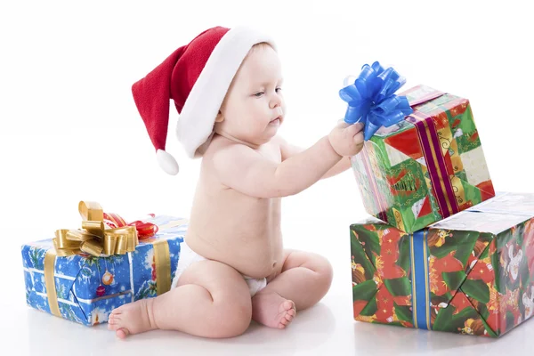 Dítě v čepici santa Claus s dárky — Stock fotografie
