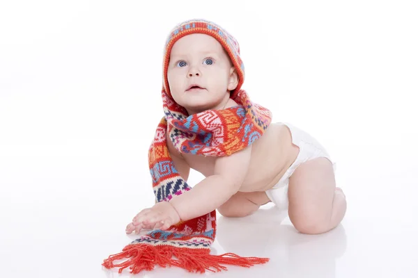 Smilende baby i strikket hat og tørklæde - Stock-foto