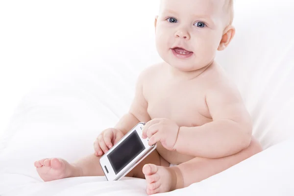 El bebé sonriente está aprendiendo a lidiar con un teléfono — Foto de Stock