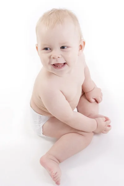 Smiling baby-boy in a diaper sitting on the floor Royalty Free Stock Photos