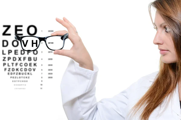 Optician giving a patient glasses to try on — Stock Photo, Image