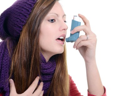 Woman with asthma using an asthma inhaler clipart