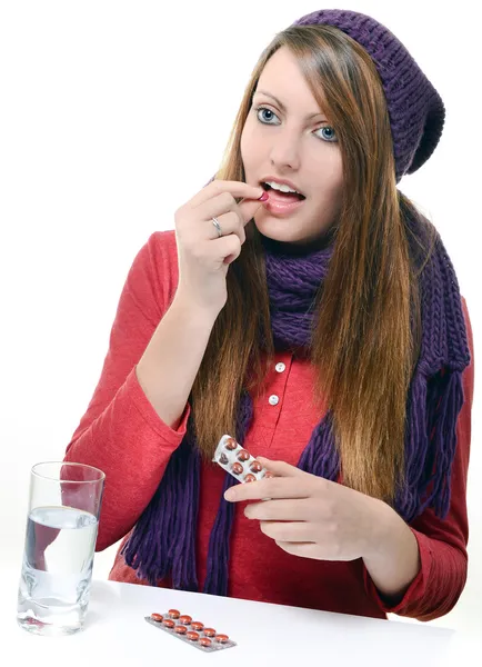 Bonito menina tomando droga contra um fundo branco — Fotografia de Stock
