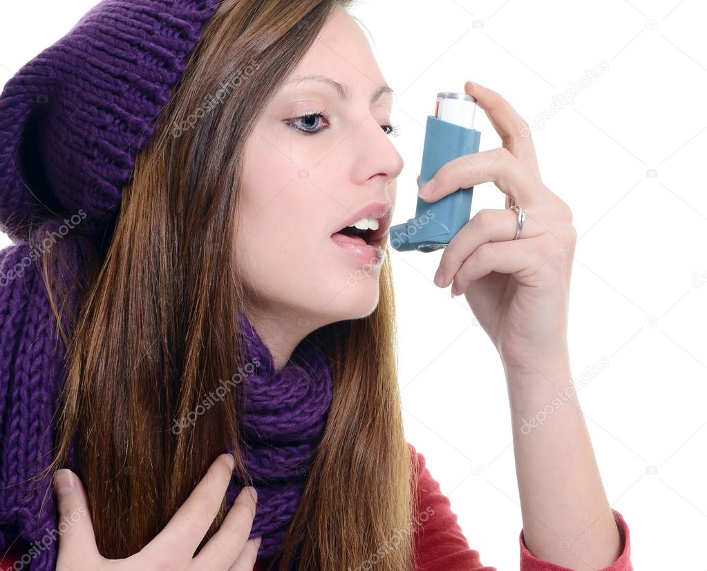 Woman with asthma using an asthma inhaler