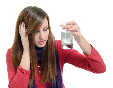 woman taking pills holding a glass of water in office clipart
