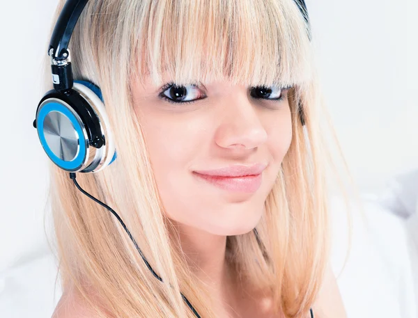 Linda chica rubia escuchando música en su teléfono inteligente — Foto de Stock