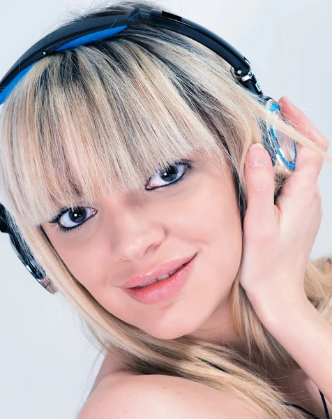 Fille attrayante écoutant de la musique avec casque bleu — Photo