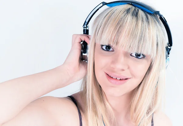 Chica alegre escuchando música con auriculares azules — Foto de Stock