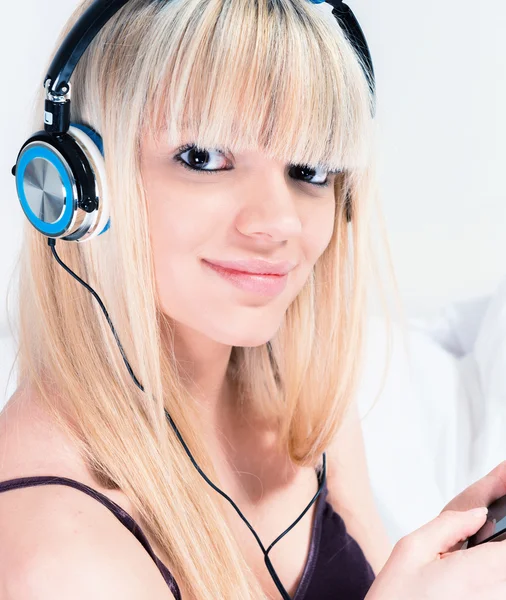 Linda chica rubia escuchando música en su teléfono inteligente —  Fotos de Stock